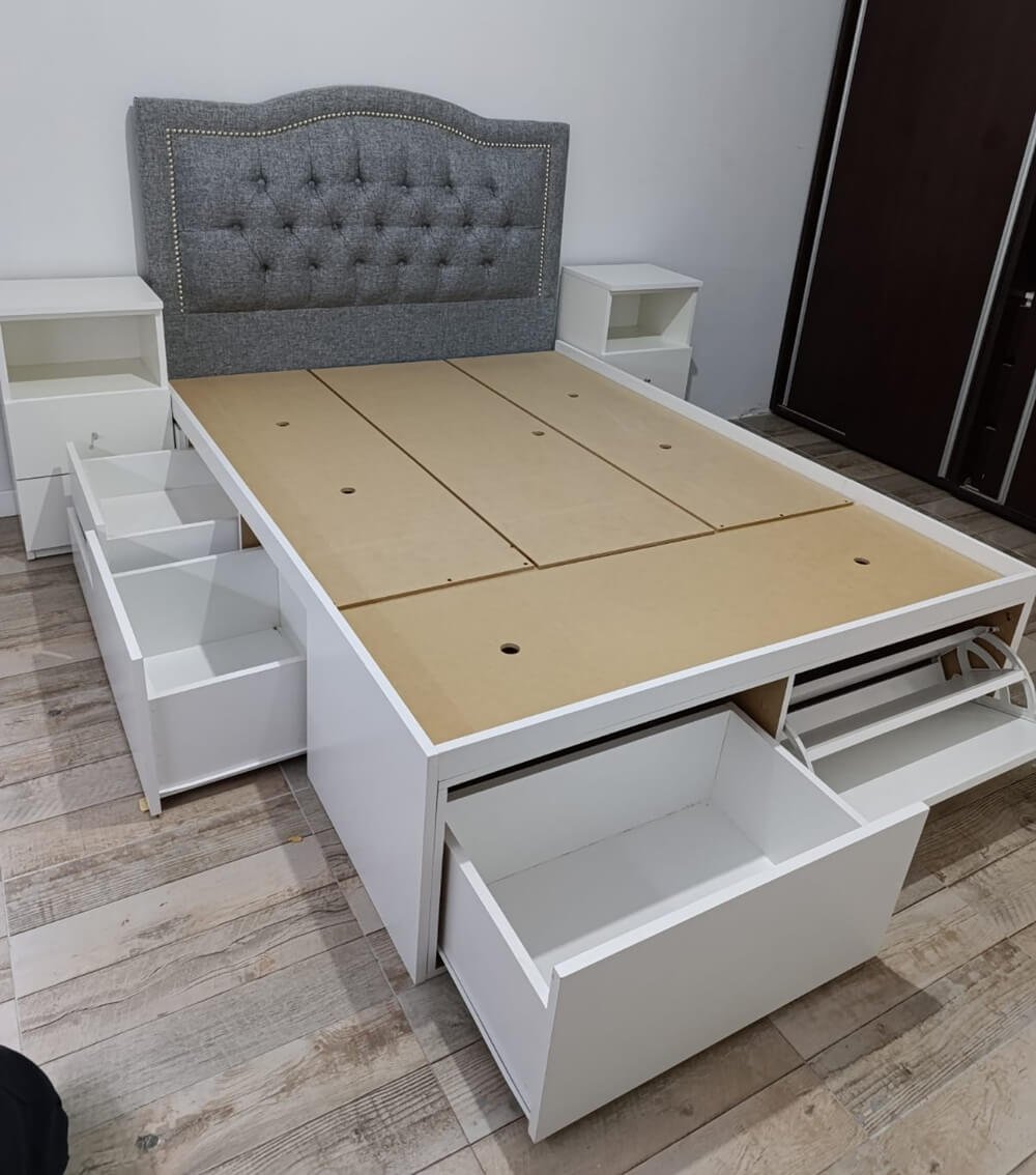 Respaldo tapizado gris con tachas y cama con cajones