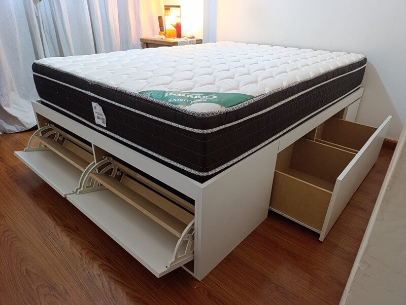 Cama con colchón instalado y cajones abiertos
