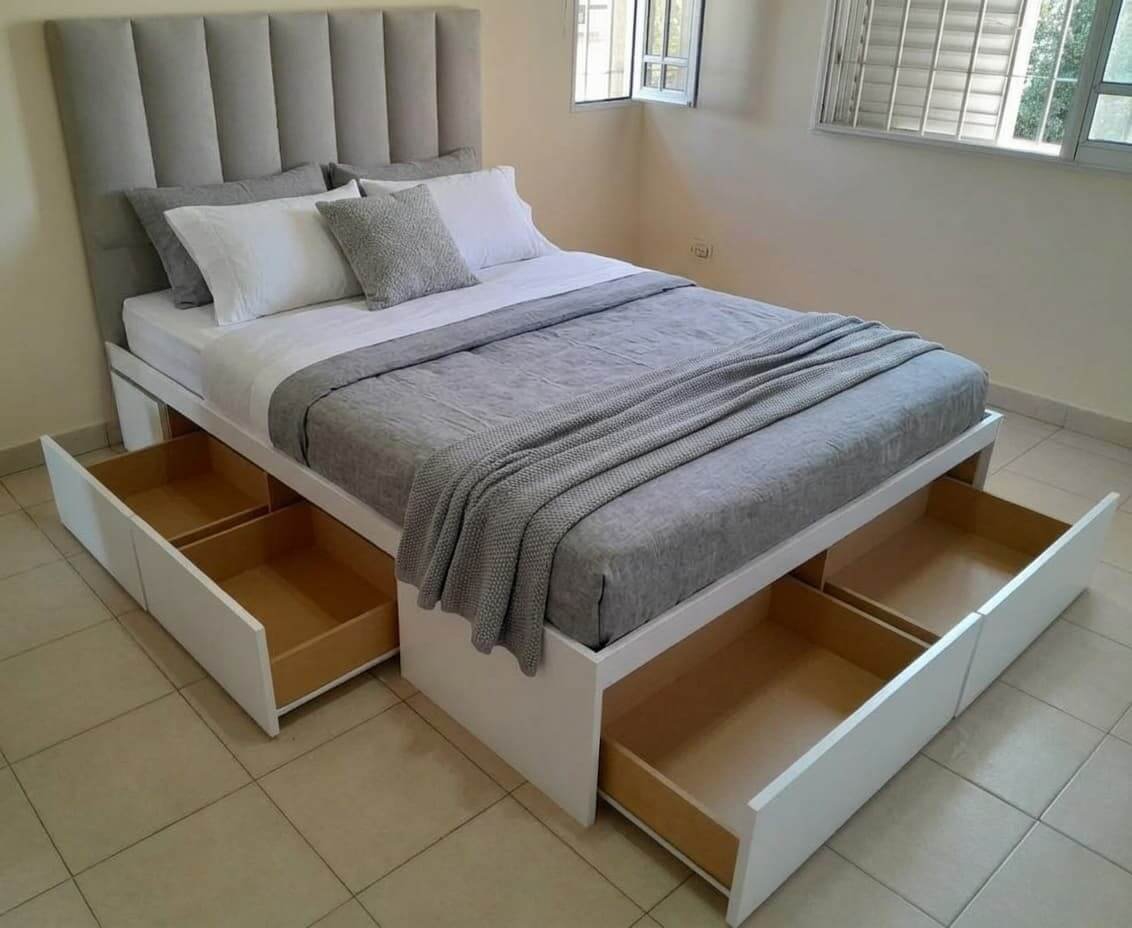 Cama con cuatro cajones abiertos y respaldo canalé gris